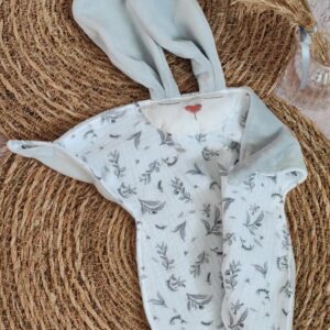 Doudou plat lapin Nuage en camaïeu de gris posé sur du jonc Cœur de Pinpin