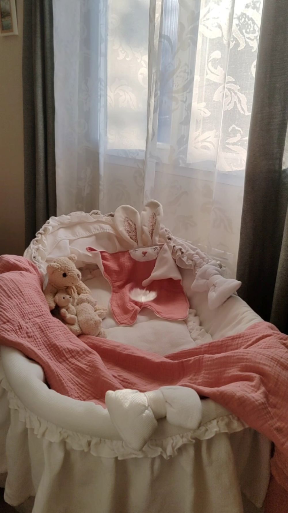 Doudou plat bébé lapin rose artisanal Cœur de Pinpin posé dans un couffin avec une plume