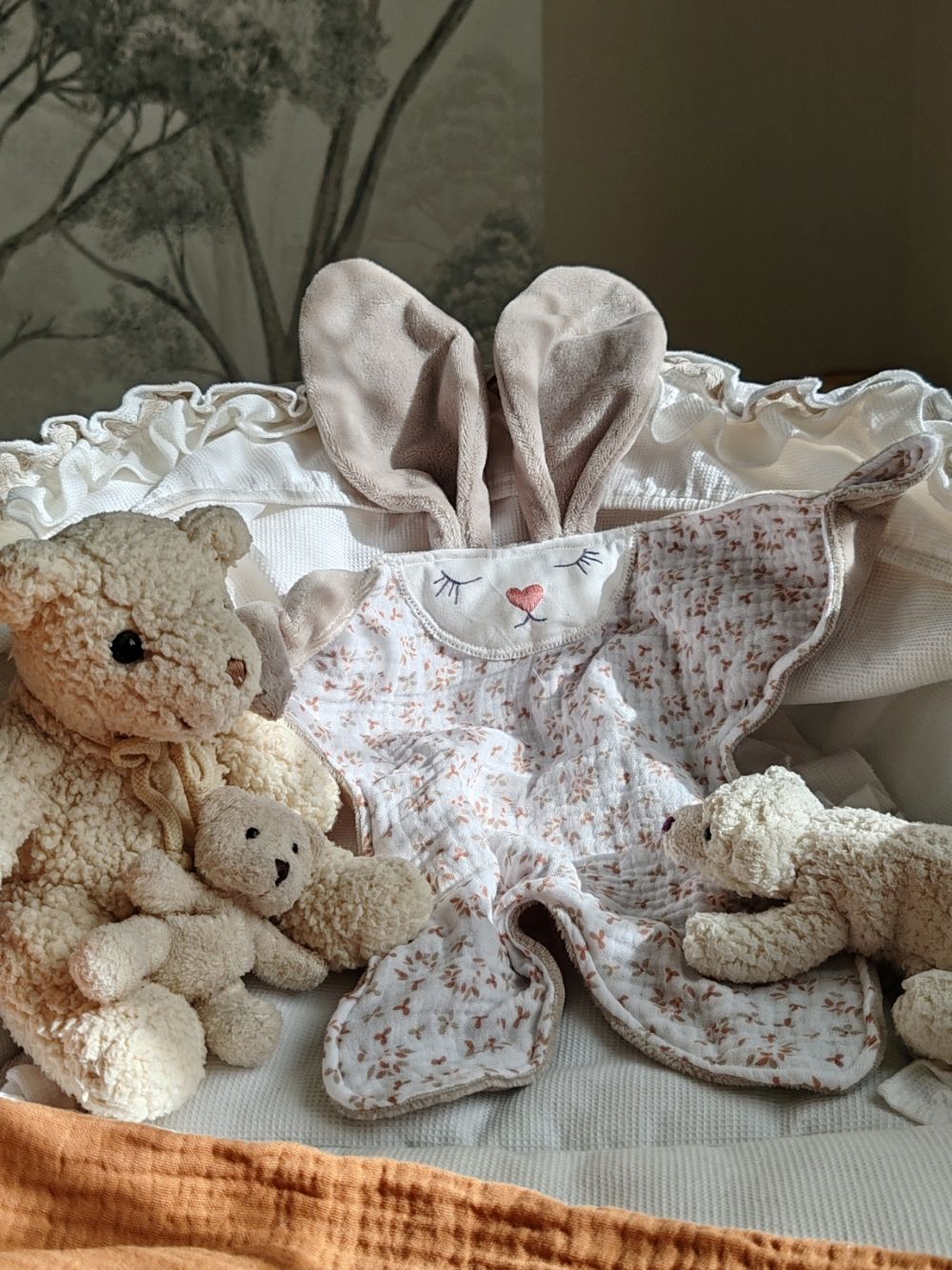 Doudou plat lapin Aube en gaze de coton fleurie et velours sable présenté dans un berceau - Cœur de Pinpin