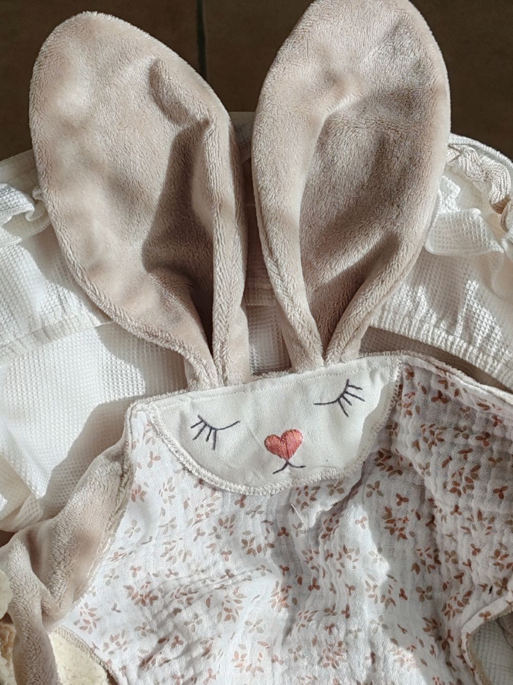 Gros plan sur les grandes oreilles en velours doux et la bouille brodée du doudou lapin Aube - Cœur de Pinpin